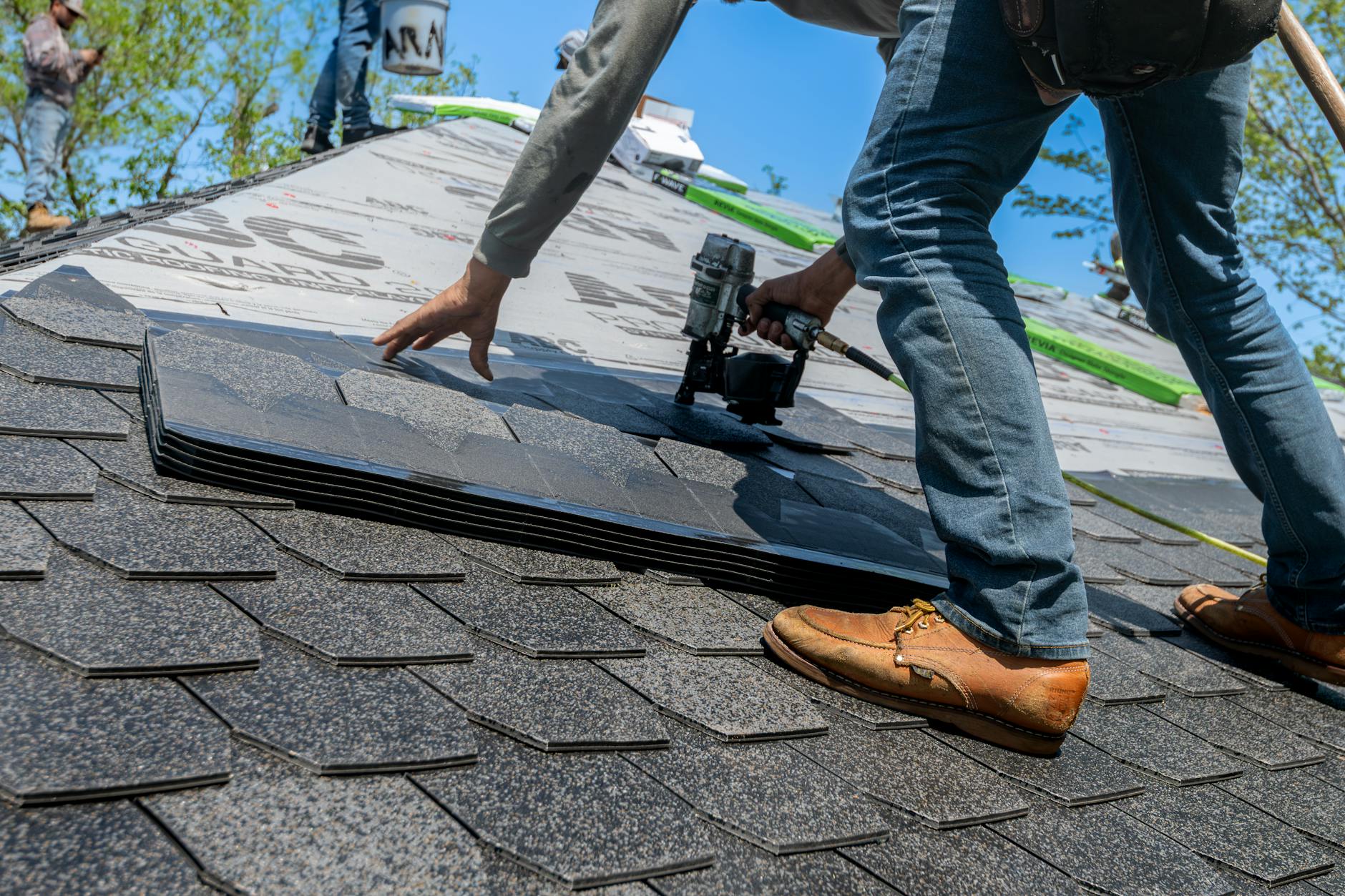 A professional roofer inspecting a tile roof underlayment on a Winchester home, ensuring proper ventilation and leak protection.